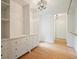 Spacious walk-in closet with custom shelves, hanging rods, and crystal chandelier at 326 Seldom Seen Trl, Canton, GA 30115