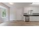 Eat-in kitchen featuring white cabinets, wood floor, stainless steel dishwasher, and natural light at 19 Willowbrook Ct, Acworth, GA 30101