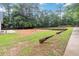 Backyard featuring a large grass area, concrete walkway, and retaining wall at 210 Riveredge Way, Mcdonough, GA 30252