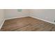 This empty bedroom features wood-look flooring, white trim and a window at 210 Riveredge Way, Mcdonough, GA 30252