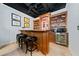 Basement bar boasts a wooden bar, barstools, and built in shelving with a beverage refrigerator at 3638 Sope Creek Farm Se, Marietta, GA 30067