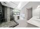 Bright bathroom with dual vanity, glass shower, skylight, stone accents, and modern fixtures at 3638 Sope Creek Farm Se, Marietta, GA 30067