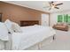 Bedroom features a sitting area, a window looking outside, ceiling fan and a comfortable queen bed at 3638 Sope Creek Farm Se, Marietta, GA 30067