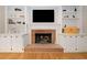 Living room fireplace with brick and built-in shelves and cabinets and mounted television at 3638 Sope Creek Farm Se, Marietta, GA 30067