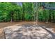 View of basketball court in backyard with view of surrounding mature trees, offering recreational space and privacy at 542 Fairway Dr, Woodstock, GA 30189