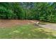 Spacious backyard features a well-maintained lawn, fire pit with chairs, and a wooded area beyond at 542 Fairway Dr, Woodstock, GA 30189