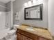 Bathroom featuring a granite vanity top, a framed mirror, and a shower-tub combo at 542 Fairway Dr, Woodstock, GA 30189