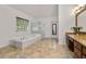 Bright and modern bathroom features a tub, glass shower and double vanity at 542 Fairway Dr, Woodstock, GA 30189