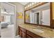 Bathroom view showcases granite countertops, wooden vanity and a large mirror at 542 Fairway Dr, Woodstock, GA 30189