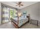 Cozy bedroom with a large window, neutral walls, and a patterned quilt at 542 Fairway Dr, Woodstock, GA 30189