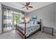 Comfortable bedroom with large window, ceiling fan and stylish decor and a decorative blue and white bed spread at 542 Fairway Dr, Woodstock, GA 30189