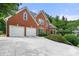 Charming two-story brick home featuring an attached two-car garage and well-manicured landscaping at 542 Fairway Dr, Woodstock, GA 30189