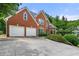 Inviting brick home featuring an attached two-car garage and a neatly paved driveway at 542 Fairway Dr, Woodstock, GA 30189