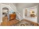 Light-filled foyer featuring hardwood floors, staircase, and an arched doorway at 542 Fairway Dr, Woodstock, GA 30189