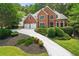 Charming brick home with a two-car garage, a well-manicured front yard, and beautiful landscaping at 542 Fairway Dr, Woodstock, GA 30189