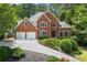 Charming brick home with a two-car garage, a well-manicured front yard, and beautiful landscaping at 542 Fairway Dr, Woodstock, GA 30189