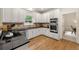 Modern kitchen boasts black countertops, stainless steel appliances, and hardwood floors at 542 Fairway Dr, Woodstock, GA 30189