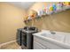 Functional laundry room with modern appliances, a practical sink, and plenty of storage for cleaning supplies at 542 Fairway Dr, Woodstock, GA 30189