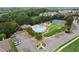 Aerial view showcases a community pool, tennis courts, and playground surrounded by lush trees at 149 Archie Way, Woodstock, GA 30188