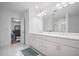Bright bathroom featuring double sink vanity with white cabinets, mirror, and access to bedroom at 149 Archie Way, Woodstock, GA 30188