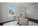 An elegantly decorated dining area featuring a modern glass table, hardwood flooring, and light gray walls at 149 Archie Way, Woodstock, GA 30188
