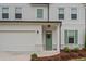 Close-up view of a charming front entrance with a green door, white siding, and well-maintained landscaping at 149 Archie Way, Woodstock, GA 30188
