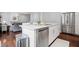 Bright kitchen boasts stainless steel appliances and an island that opens to a living area with a fireplace at 149 Archie Way, Woodstock, GA 30188
