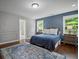 Bedroom showcasing blue accent wall, hardwood floors, and natural light at 149 Archie Way, Woodstock, GA 30188