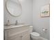 Stylish powder room features elegant vanity, round mirror, and charming flamingo artwork at 149 Archie Way, Woodstock, GA 30188