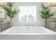 Close-up of a soaking tub surrounded by vanities and greenery at 2063 Wheaton Way, Sandy Springs, GA 30328