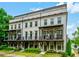 Charming townhome with a brick facade, complemented by stylish balconies and lush green landscaping at 2063 Wheaton Way, Sandy Springs, GA 30328