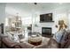 Open-concept living room with a fireplace, hardwood floors, and a seamless flow to the dining area at 2063 Wheaton Way, Sandy Springs, GA 30328