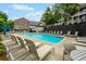 Community pool with lounge chairs, manicured greenery, and a nearby building, ideal for relaxing and socializing at 2063 Wheaton Way, Sandy Springs, GA 30328
