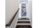 Staircase with a built-in bookshelf that is stocked with a variety of books and decorative items at 2063 Wheaton Way, Sandy Springs, GA 30328