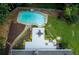 Aerial view showcases the backyard with a pool, deck, manicured lawn, mature landscaping, and privacy fence at 3261 Stonecreek Ct, Suwanee, GA 30024