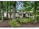 Charming home featuring a tan stucco exterior, complemented by mature trees and lush landscaping at 3261 Stonecreek Ct, Suwanee, GA 30024