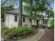 Side view of a tan stucco home showcasing manicured landscaping and stone-lined walkway at 3261 Stonecreek Ct, Suwanee, GA 30024