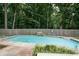 Backyard pool surrounded by a wooden fence and lush greenery at 3261 Stonecreek Ct, Suwanee, GA 30024