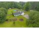 Aerial view of a light green home with a large yard and inground pool surrounded by mature trees at 1789 Brandi Ln, Loganville, GA 30052