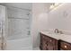 Bathroom featuring marble tile surround, bathtub and shower, and a dark wood vanity at 1789 Brandi Ln, Loganville, GA 30052