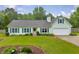 Light green single-story home with blue shutters, a two-car garage, and a well-kept lawn at 1789 Brandi Ln, Loganville, GA 30052