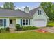 Close-up of a light green home with blue shutters, an attached garage, and manicured landscaping at 1789 Brandi Ln, Loganville, GA 30052