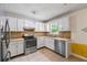 Well-lit kitchen featuring white cabinets, stainless steel appliances, and decorative pebble backsplash at 1789 Brandi Ln, Loganville, GA 30052