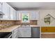 Stylish kitchen area with stainless steel appliances and unique stone tile backsplash at 1789 Brandi Ln, Loganville, GA 30052