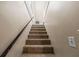 Carpeted staircase with a dark handrail at 1789 Brandi Ln, Loganville, GA 30052