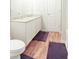 Bright bathroom featuring a granite-topped double vanity, white cabinets, and wood-look flooring at 20 Sloane Ct, Covington, GA 30016