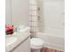 Stylish bathroom with granite vanity, white cabinets, shower-tub combo and patterned shower curtain at 20 Sloane Ct, Covington, GA 30016