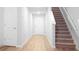 Hallway with hardwood-style flooring, leading to the stairs and other rooms in the home at 20 Sloane Ct, Covington, GA 30016