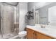 A well-lit bathroom with a walk-in shower, modern fixtures, a vanity, and storage shelves at 2114 Gorman Se Grv, Atlanta, GA 30316