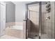 Bathroom featuring a soaking tub with a tiled shower behind glass doors at 2114 Gorman Se Grv, Atlanta, GA 30316